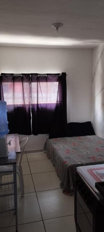 a bedroom with a bed and a window at Kitnet para Hospedagem in Caruaru