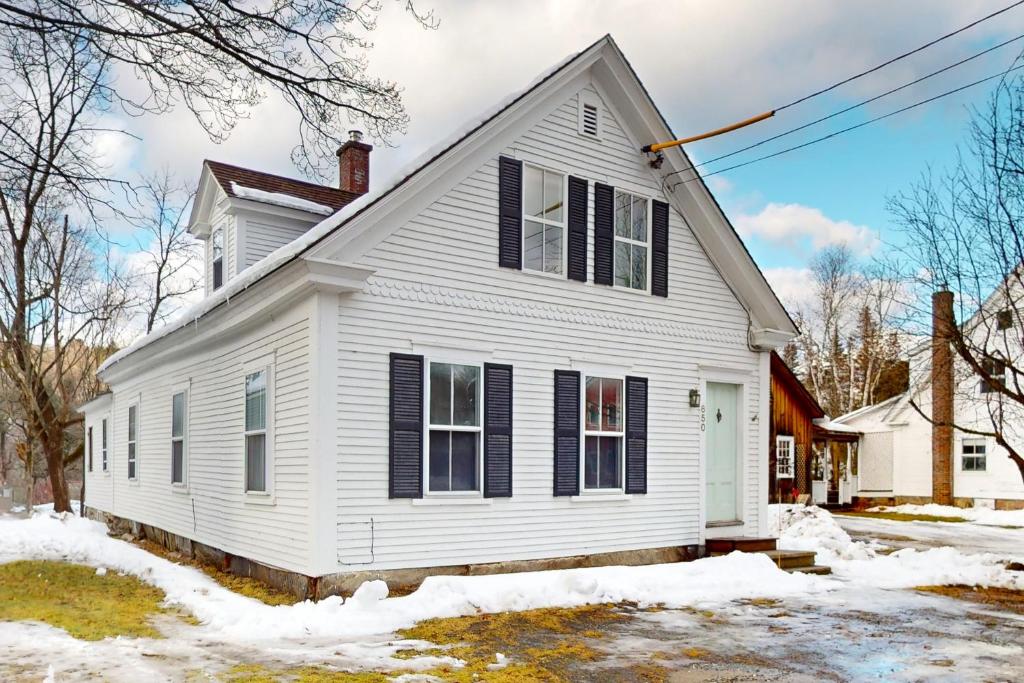 Green Door Cottage في Weston: منزل أبيض مع مصاريع سوداء