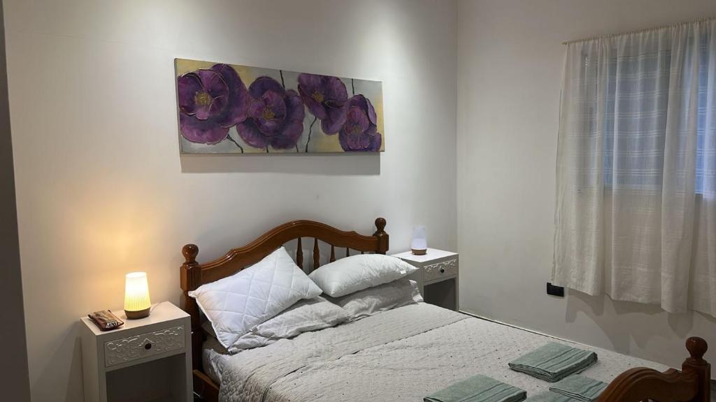 a bedroom with a bed with two night stands and a window at Don Tino in San Pedro