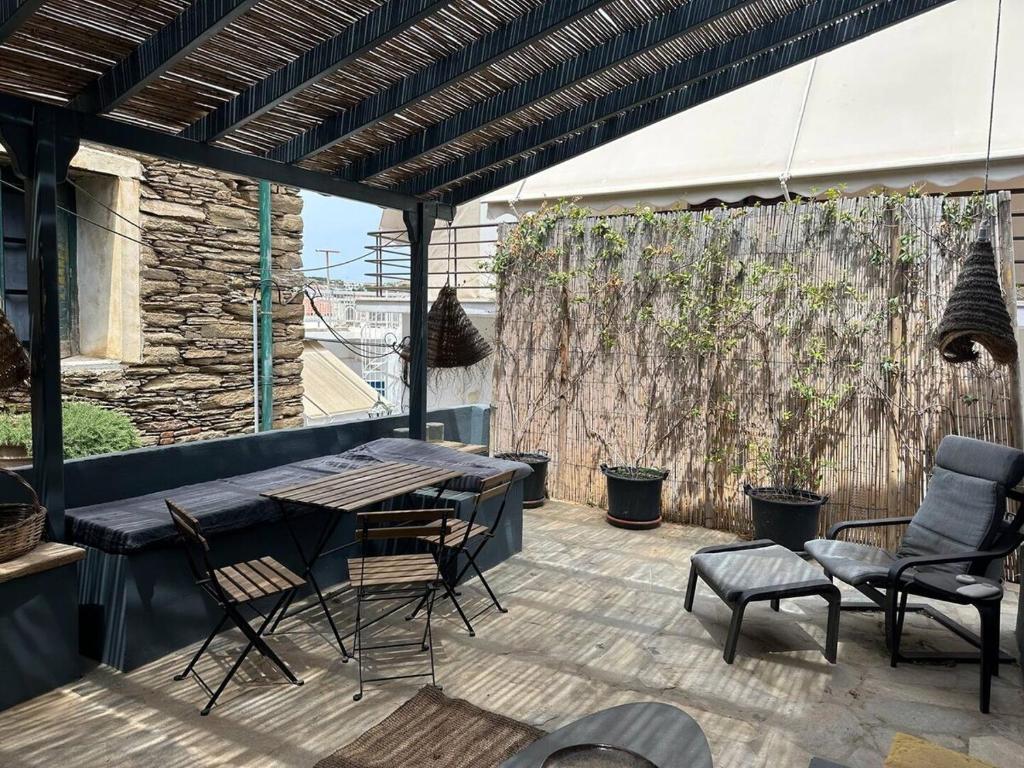 un patio con tavolo, sedie e una recinzione di Boho Chic in Central Mpatsi! a Mpatsi (Batsi)