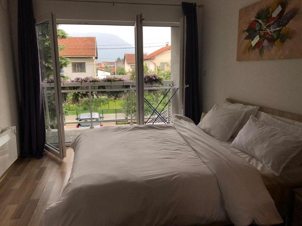 a bed in a bedroom with a large window at Sweet family home in Doglodi