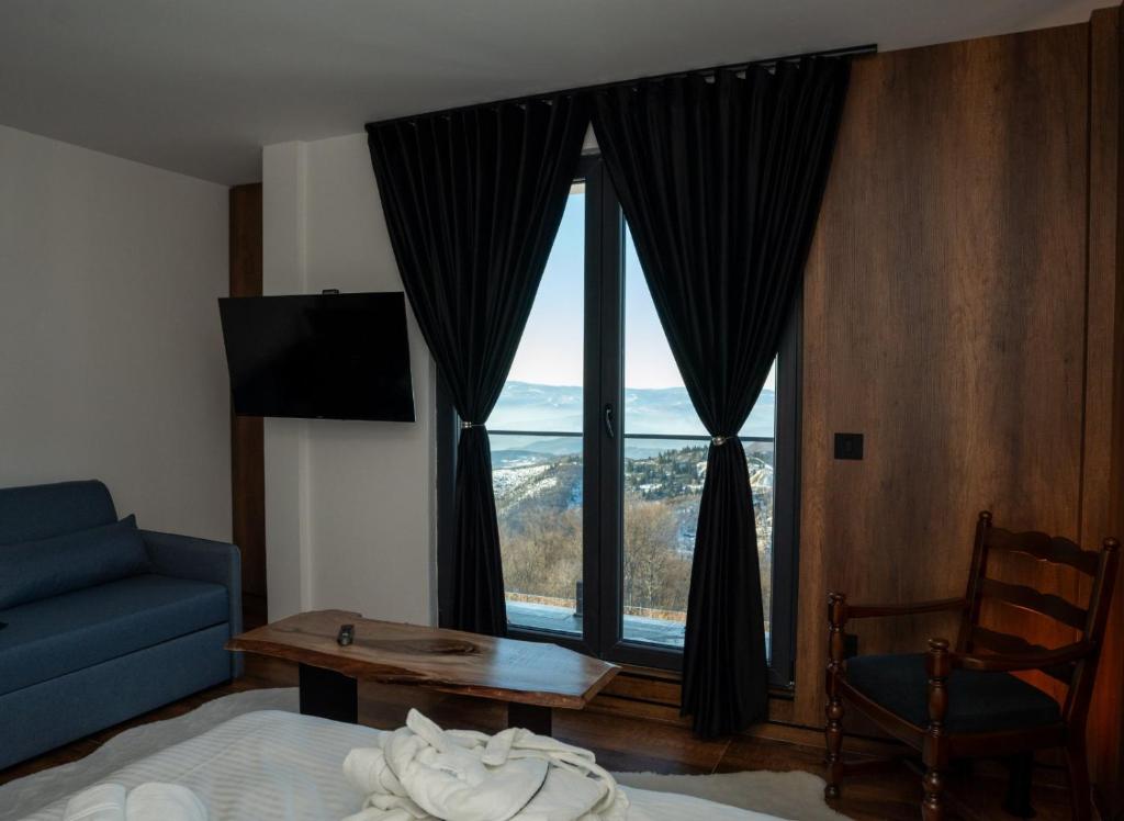 科帕奥尼克KonKal - Royal resort的一间卧室设有蓝色的沙发和大窗户