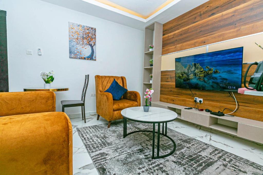 阿克拉Aster Luxury Apt close to Airport & Mall with Rooftop pool & gym的带沙发、桌子和电视的客厅