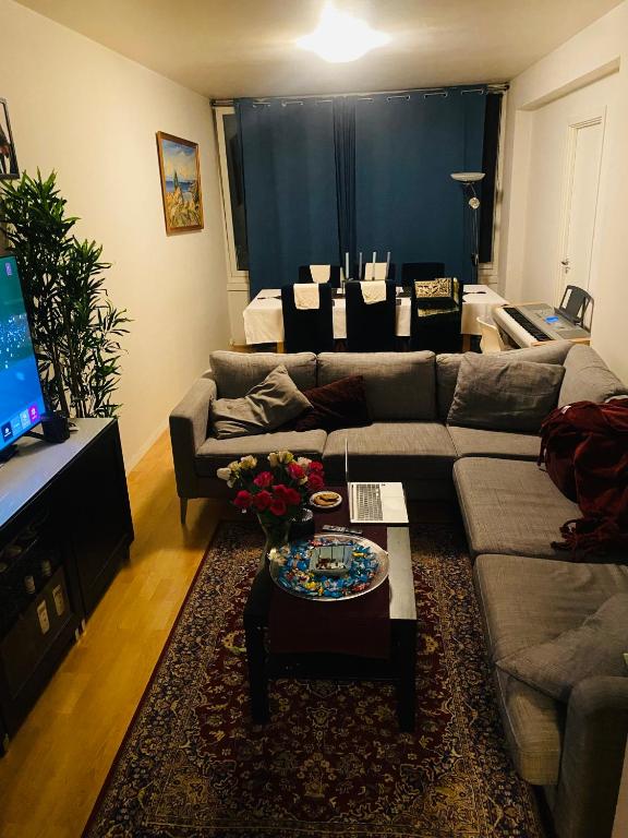 a living room with a couch and a table at Room in 2 bedroom apartment in Lijordet