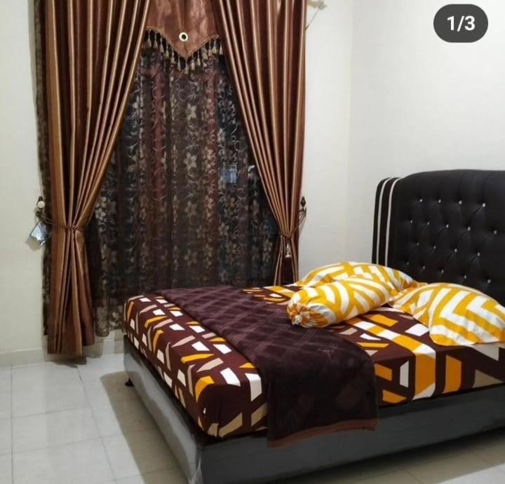 a bed sitting in a room with a window at Dahniar Syariah Homestay in Baso