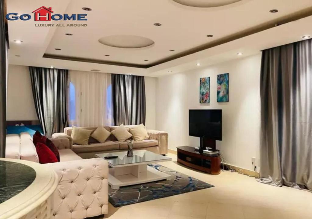 a living room with a couch and a tv at Pretty 4Bedrooms Penthouse MB7 at New Abu Tig Marina in Hurghada