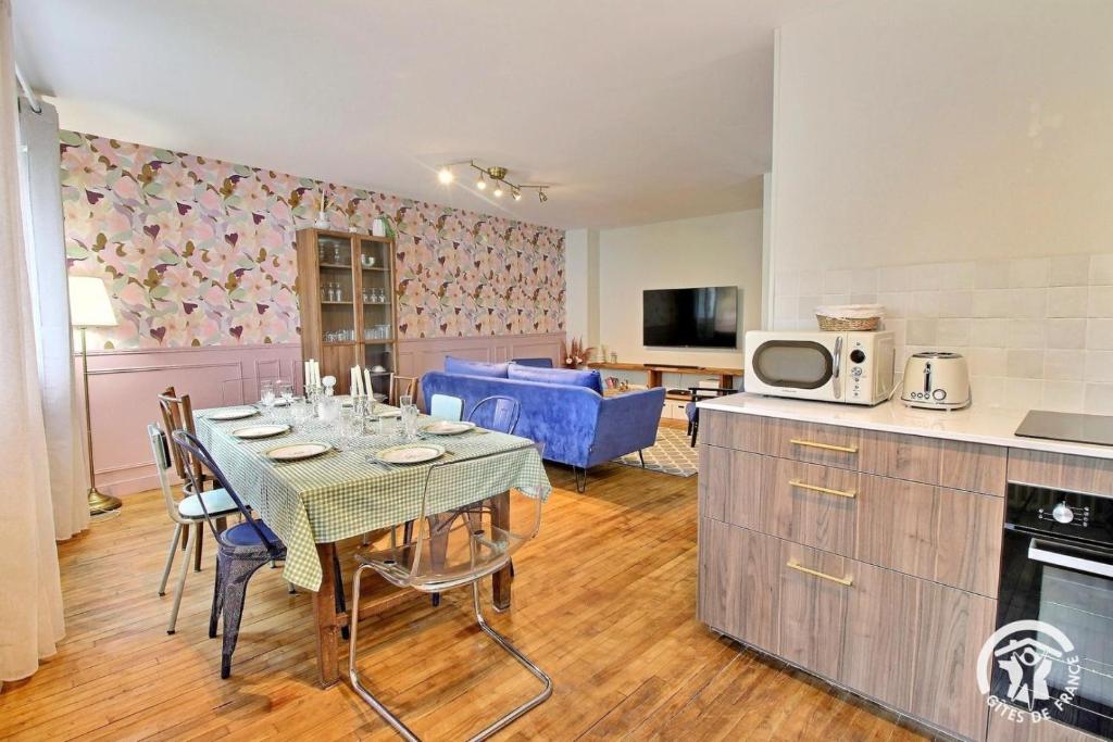 a kitchen and dining room with a table with chairs at La rose des vents in Pontivy
