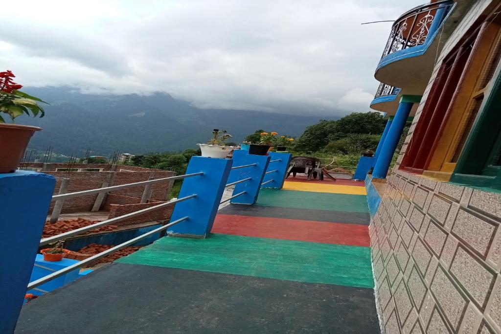 a stairway with a rainbow flag painted on it at Hotel O Snow Pine Guest House Tosh in Manīkaran