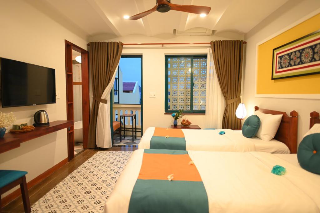 Postel nebo postele na pokoji v ubytování De'Colore Villa Hoi An