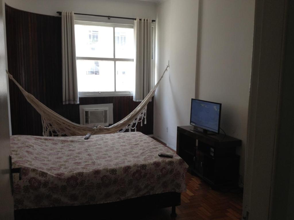 1 dormitorio con hamaca y TV en Apartamento Nossa Senhora, en Río de Janeiro