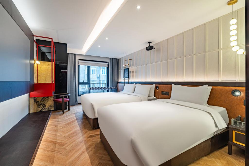 Postel nebo postele na pokoji v ubytování Beijing Tangfu Sanlitun BOUTIQUE Hotel---Breakfast, restaurant and bar, close to Tian'anmen Square Forbidden City Temple of Heaven, laundry, gym, robot, ticket service, located in city center Metro line 2, one station to Airport Express