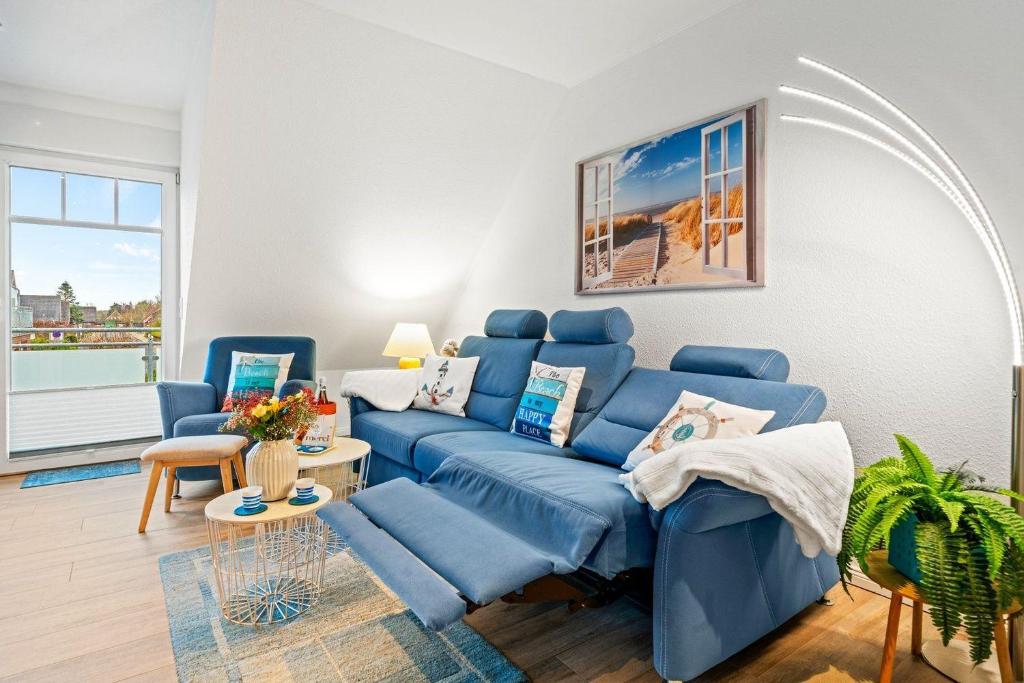 ノルトダイヒにあるAm-Nordmeerstrandの青いソファと椅子のあるリビングルーム