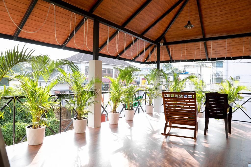 a room with potted plants and a table and chairs at Coconad Resort in Alleppey