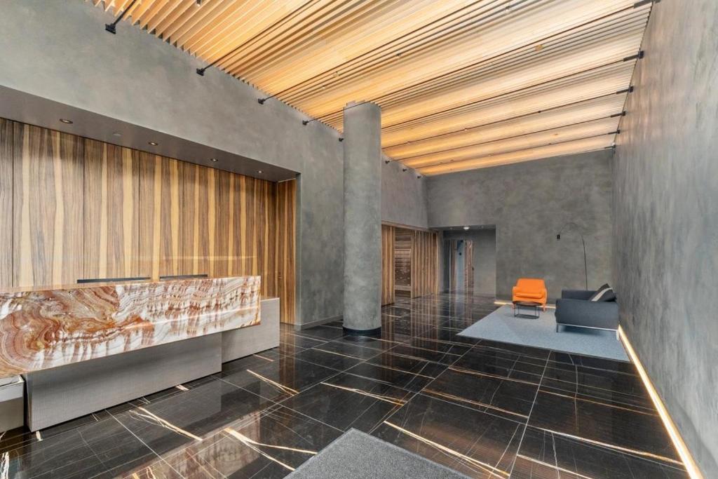 een lobby met een oranje stoel in een kamer bij Boutique New 1-Bedroom Condo in Heart of Downtown in Vancouver