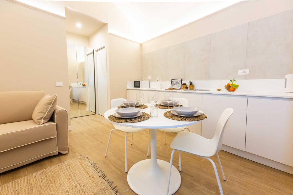 a kitchen and dining room with a white table and chairs at Monti Nonna Francesca - ZENO 49 in Rome