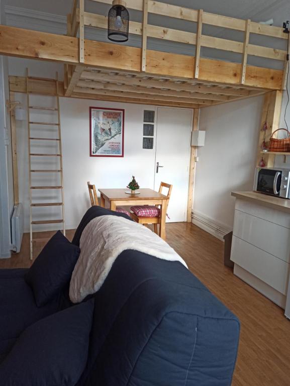 - une chambre avec un lit, une table et une mezzanine dans l'établissement Appartement à la montagne, à Saint-Bonnet-en-Champsaur