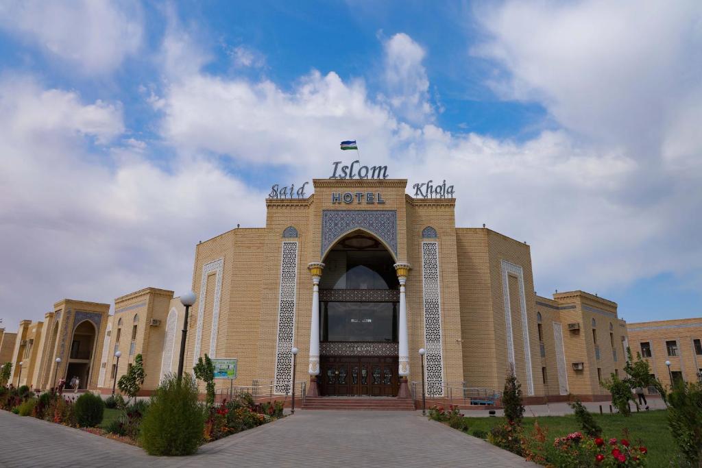 un edificio con una entrada con una bandera en la parte superior en Said Islom Khoja, en Khiva