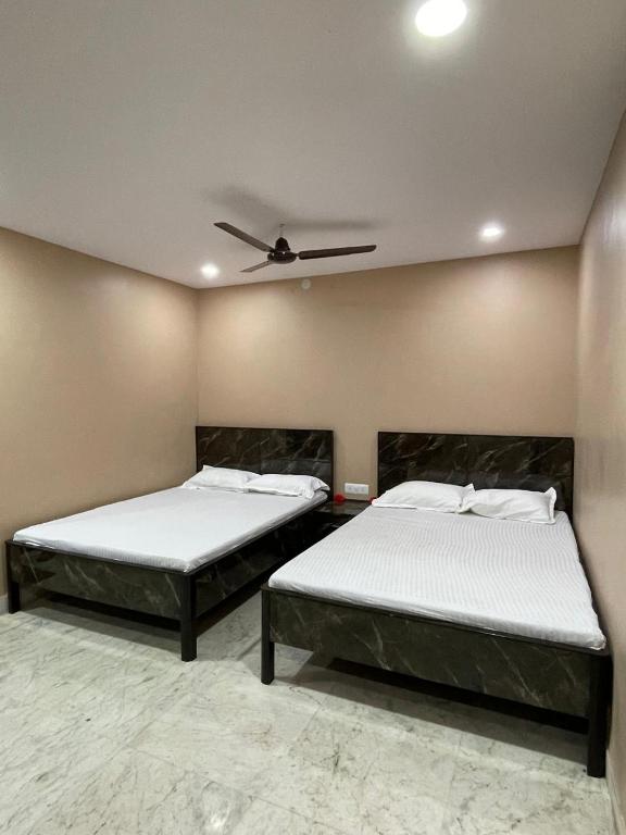 2 letti in una camera con soffitto di Crystal Inn a Salkhia
