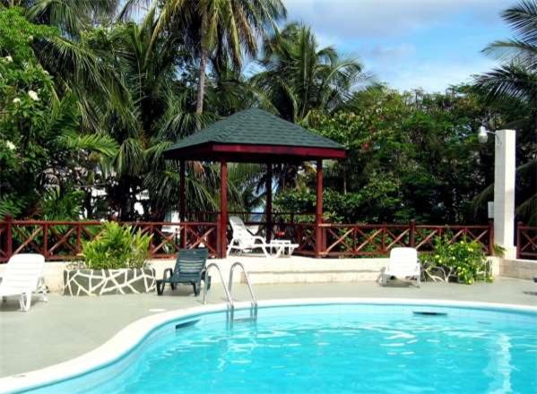 a pool with a gazebo and chairs and a umbrella at The Legend Garden Condos in Saint Peter