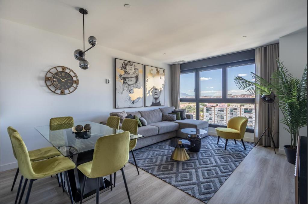 a living room with a couch and a table and chairs at ANSA Beach Apartments - Malaga - Skyline Suite in Málaga