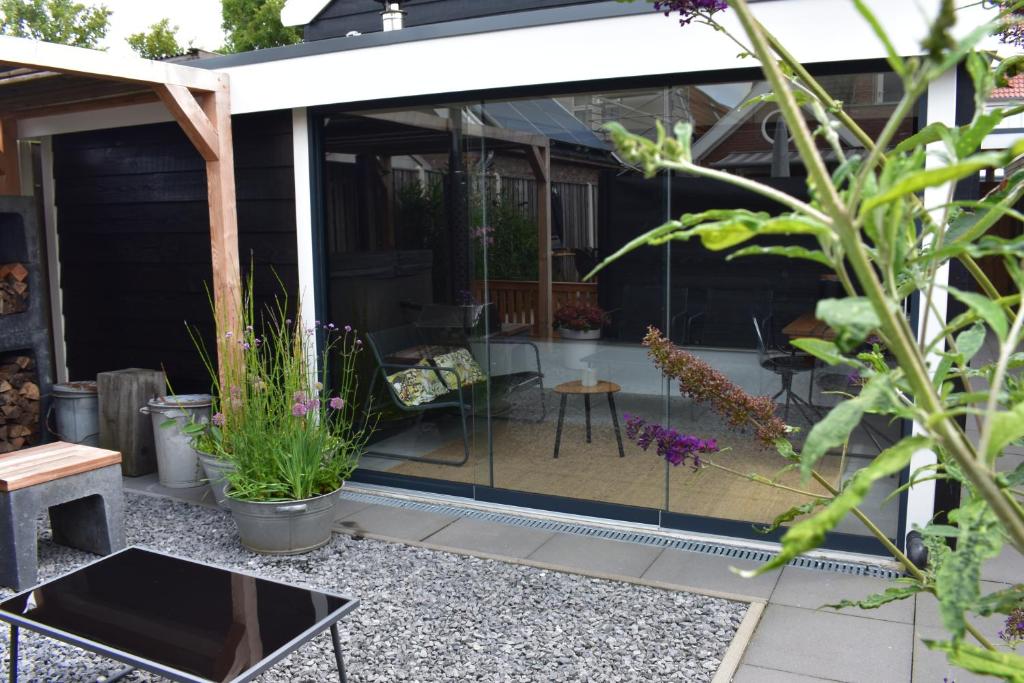 a screened in patio with a table and some plants at van Harte in Zeeland in Kamperland