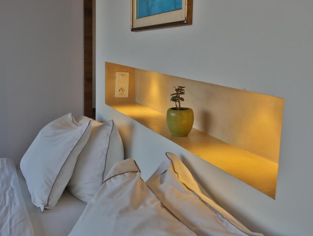 a bedroom with a white bed with a potted plant at Dar Souad in La Marsa