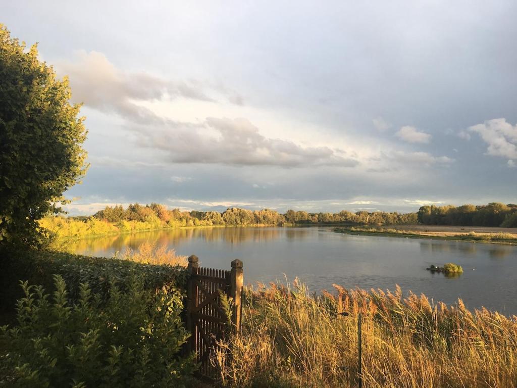 a view of a river with a wooden fence at La Ronce in Châteauneuf-sur-Loire