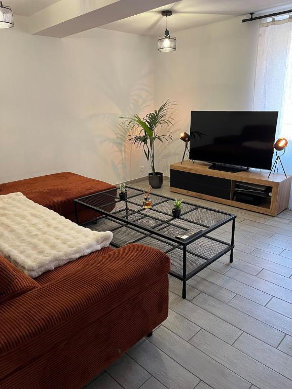 un salon avec un canapé et une télévision à écran plat dans l'établissement Le Nid ideal, au Muy