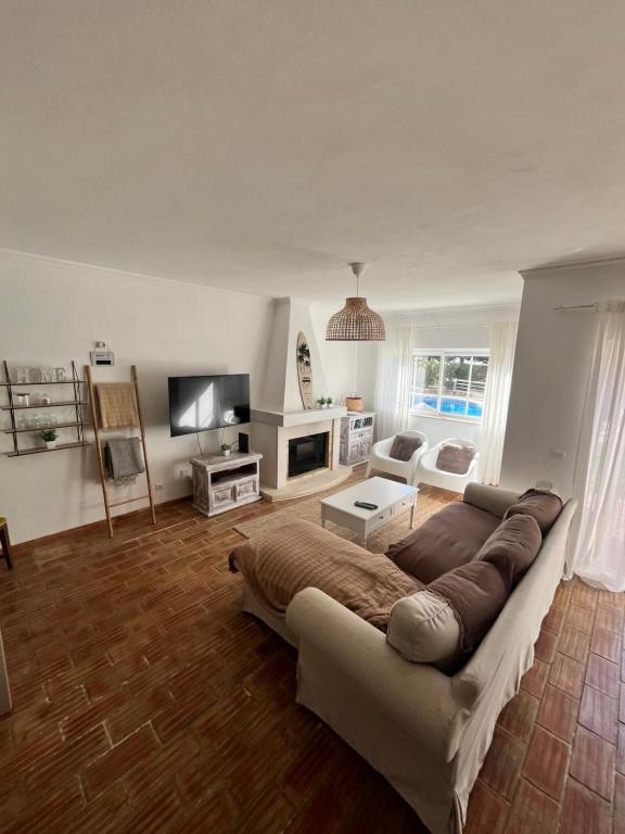 a living room with a large couch and a tv at Casa Da Praia in Luz