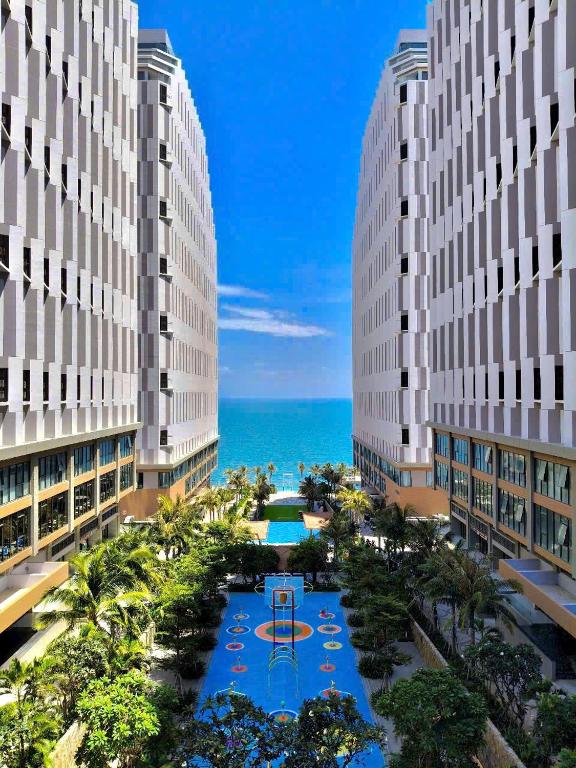 a view of two tall buildings with a basketball court between them at Apec Nirvana Peace Mui Ne in Mui Ne