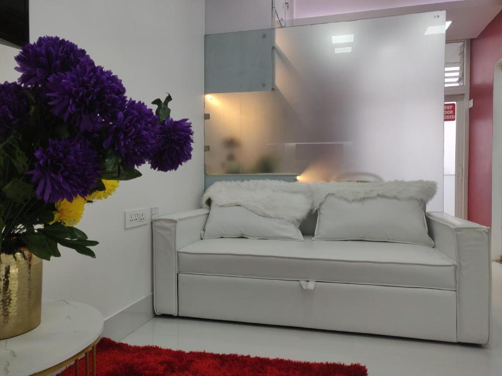 グルガオンにあるLeModCasa - Smart, modern, Luxury Whitehouseの紫の花が咲くリビングルームの白いソファ
