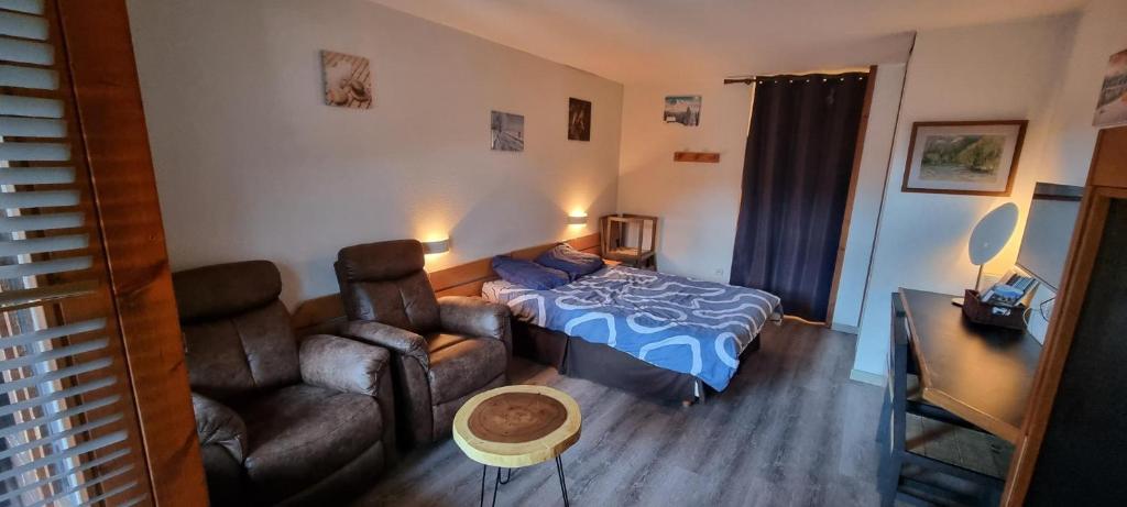 une chambre avec un lit, un canapé et une chaise dans l'établissement Appartement en résidence Brides les Bains, à Brides-les-Bains