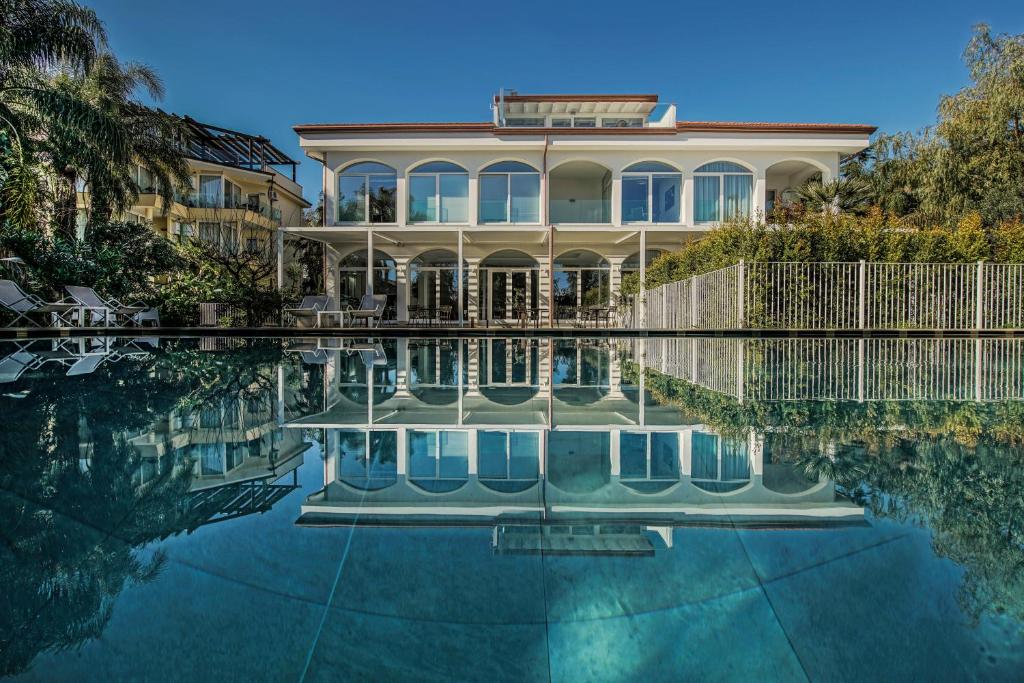 アーチ・トレッツァにあるSicilia's Art Hotel & Spaの水のプールが目の前にある家