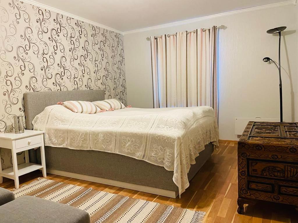 a bedroom with a bed and a table and a window at Stor enebolig sentralt på Senja in Senja