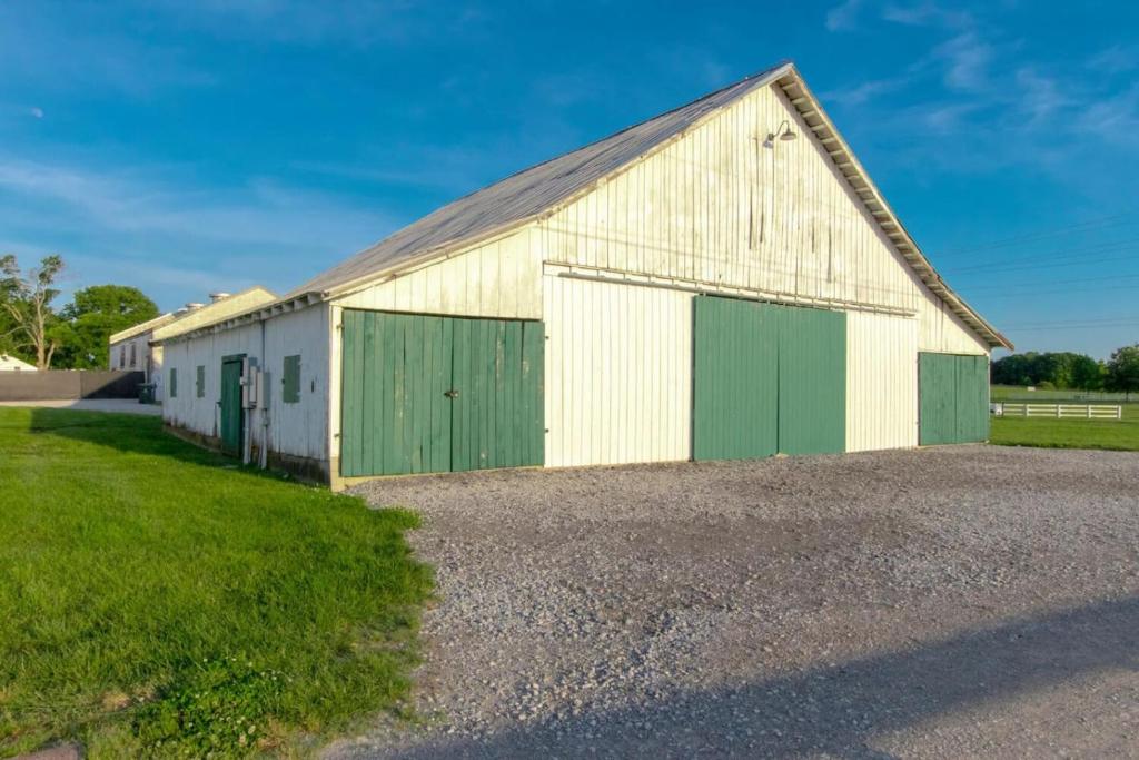 a large white and green barn with green doors at Spacious 3 Bedroom Historic Franklin Quadplex in Franklin