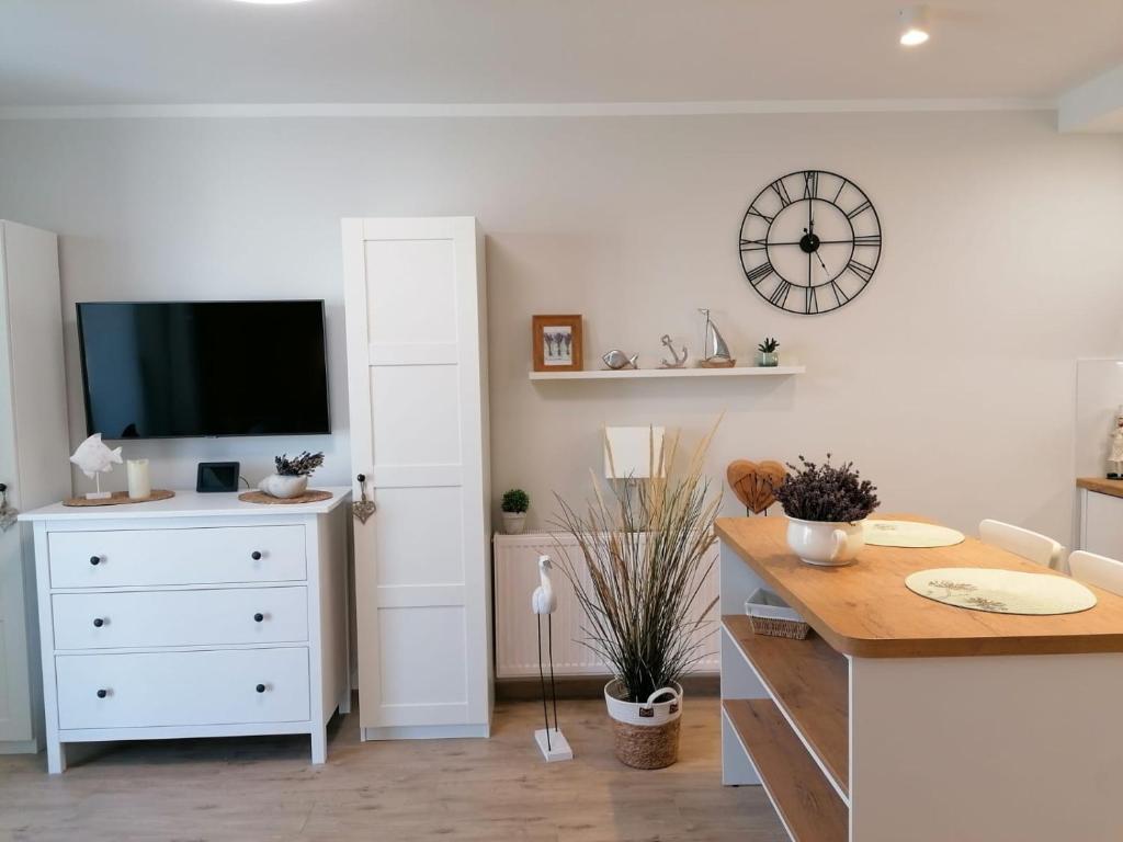 une cuisine avec une commode et une horloge murale dans l'établissement Appartment Alicja, à Darłowo
