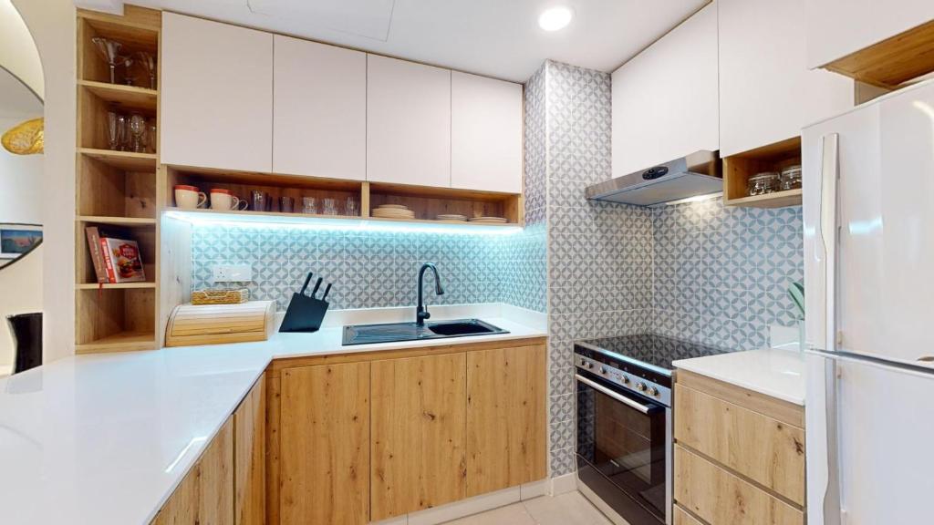 a kitchen with white cabinets and a sink at Murjan 2 - Upgraded Studio with Partial Sea View in Dubai