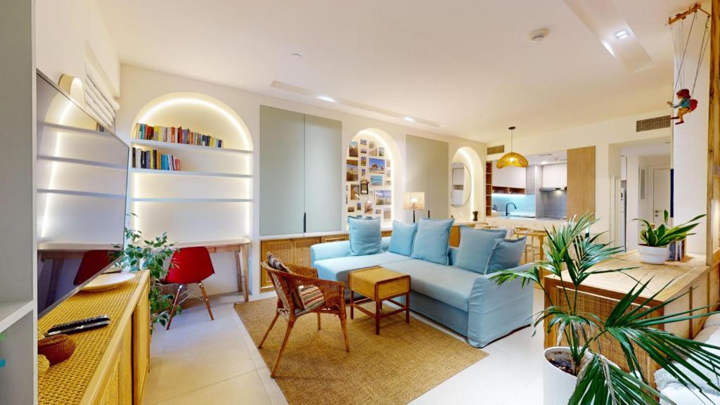a living room with a blue couch and a table at Murjan 2 - Upgraded Studio with Partial Sea View in Dubai