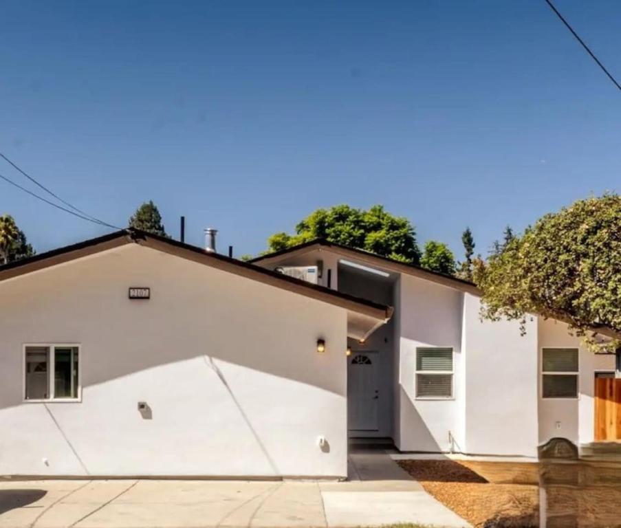 a white house with a garage at PALO ALTO PRIVATE APARTMENT with kitchen, laundry and Near Stanford in East Palo Alto