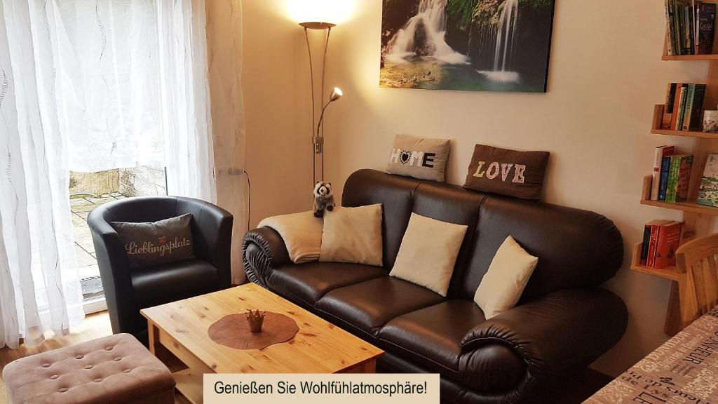 a living room with a leather couch and a table at Ferien am Bergpark - Kassel, Bad Wilhelmshöhe in Kassel