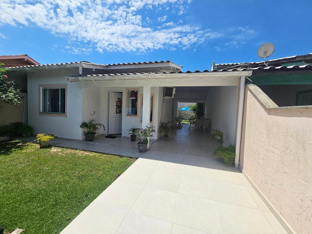 a white house with a porch and a patio at Casa Brisa da ilha in Florianópolis