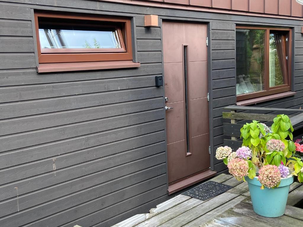 Hotel T kan Verkeren - Houseboat, a house with a door and flowers in front of it at T kan Verkeren - Houseboat in Amsterdam