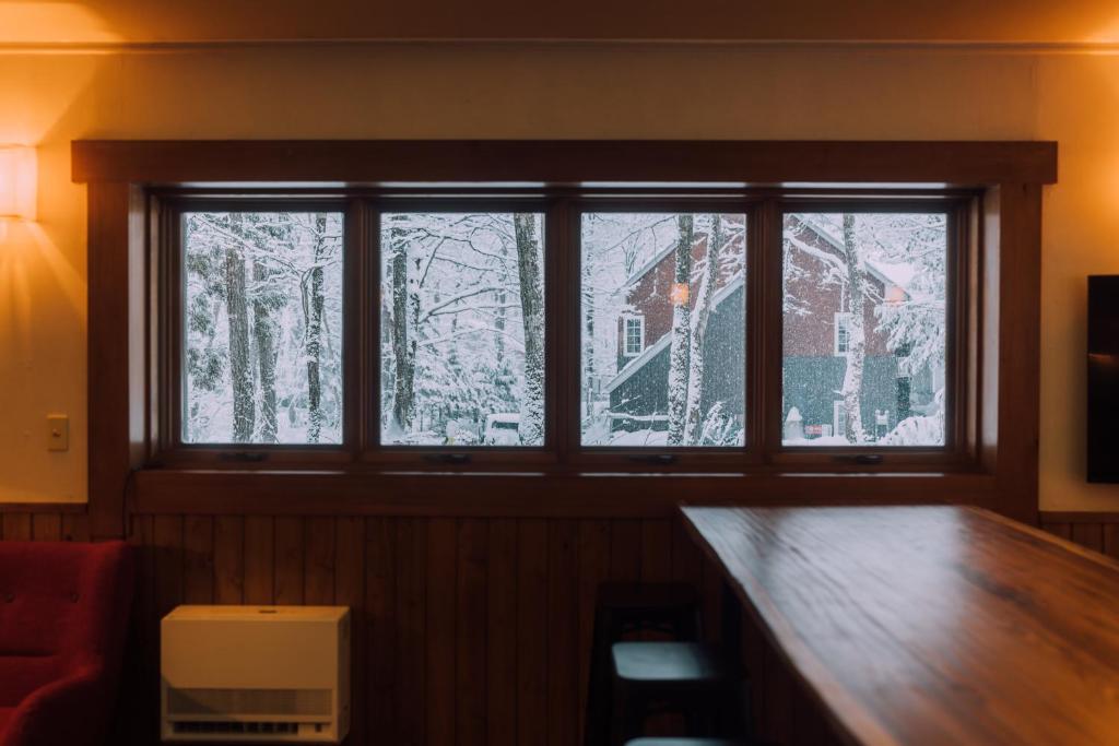 a window in a room with snow on the trees at Double Black Hotel in Hakuba