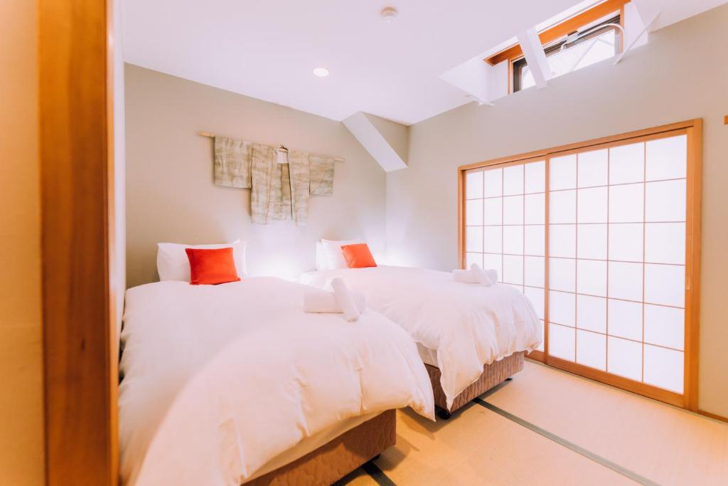 two beds in a room with a window at Double Black Hotel in Hakuba