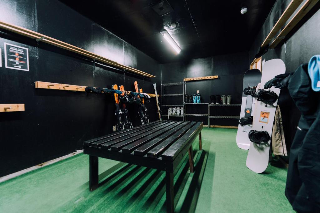 a room with a bench in a hockey room at Double Black Hotel in Hakuba