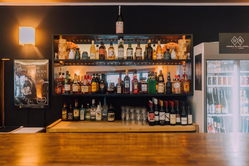 a bar with a lot of bottles of alcohol at Double Black Hotel in Hakuba