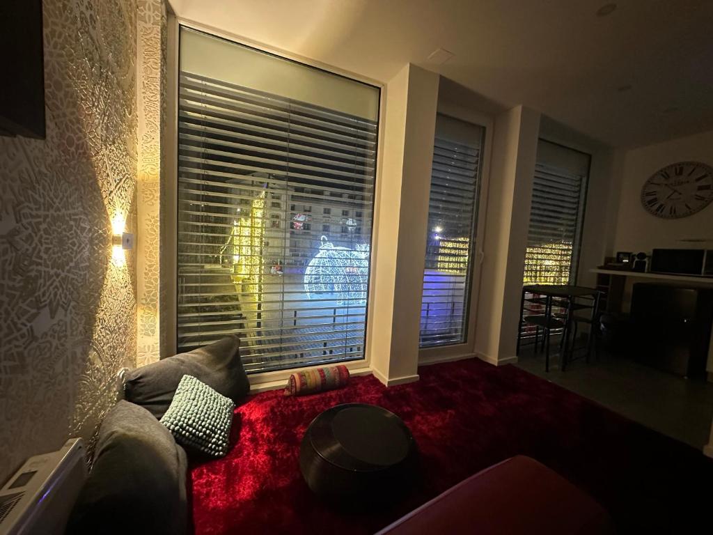 Una sala de estar con un sofá y una ventana grande. en Ruby, en Longwy