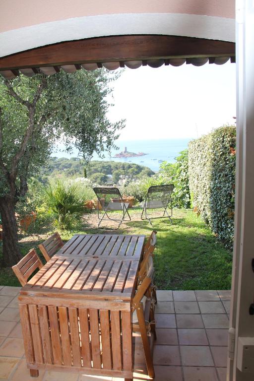 - un banc en bois sur une terrasse avec vue dans l'établissement Villa au Village de Cap Esterel, à Saint-Raphaël