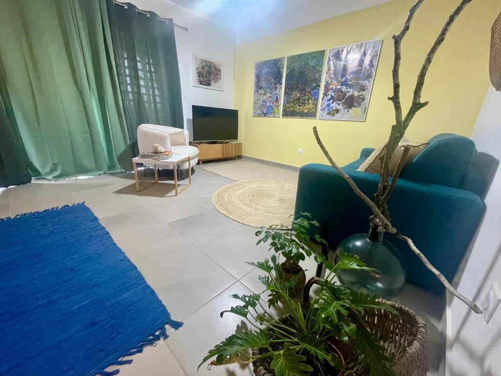 RémiréApt 1 chb belle déco résidence avec piscine的客厅里有一张蓝色沙发和一台电视