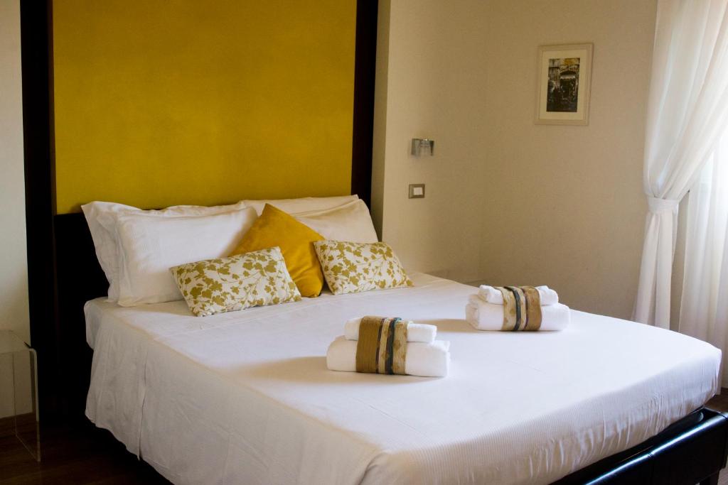 duże białe łóżko z dwiema poduszkami w obiekcie Al centro di Roma w Rzymie